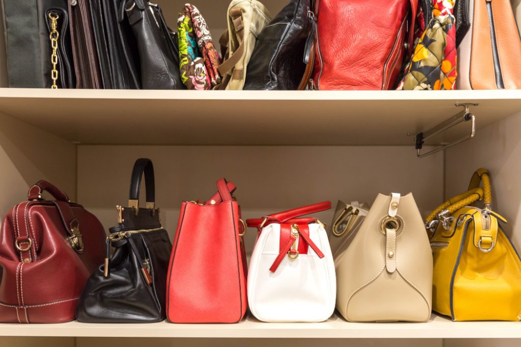 collection of handbags in woman's closet