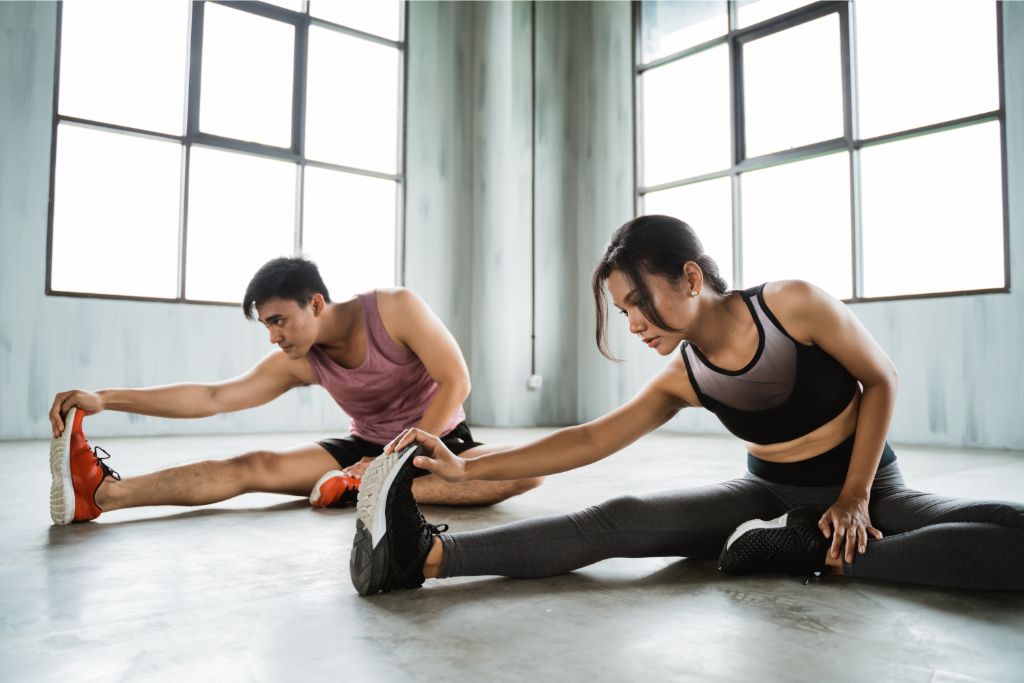 a man and woman doing stretching exercise