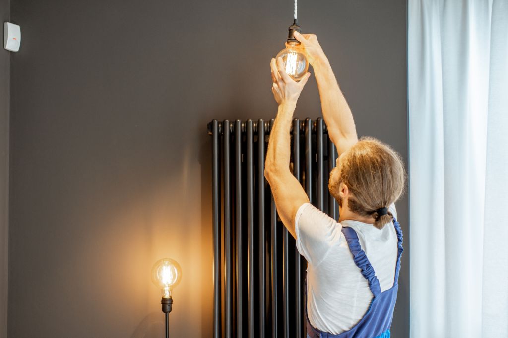 handyman replacing lightbulb at home