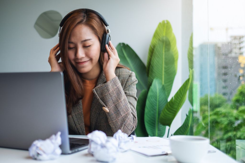 woman working at office while listening to music
