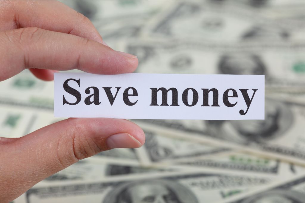 person holding a small piece of paper showing save money text